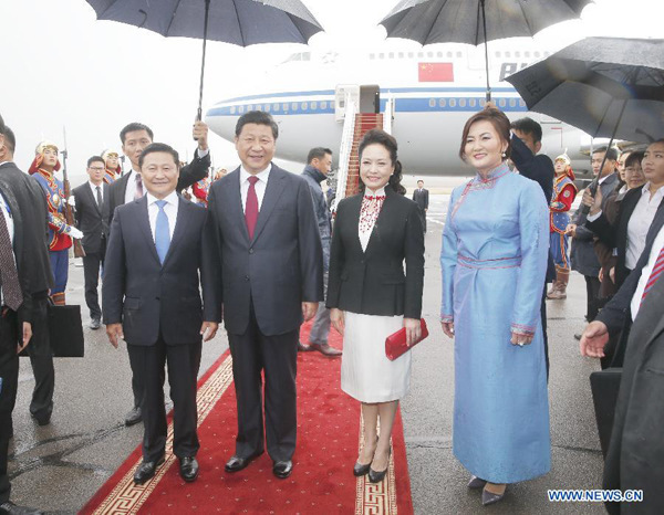 Chinese President Xi Jinping and his wife Peng Liyuan are greeted by Mongolian Prime Minister Norov Altankhuyag and his wife at the airport in Ulan Bator, Mongolia, Aug 21, 2014. Xi arrived in Ulan Bator Thursday for a two-day state visit to Mongolia. (Xinhua/Ju Peng)
