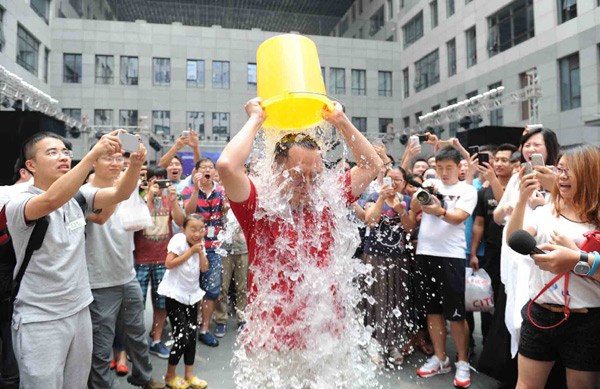Zhou Hongyi, founder of anti-virus software company Qihoo 360, takes part in the Ice Bucket Challenge in Beijing on Monday. The challenge, in which participants are dared to have a bucket of iced water poured over their heads, is aimed at raising money for patients with ALS, a neurodegenerative disorder that is often referred to as Lou Gehrig's disease. [Photo by Yan Tong/for China Daily]