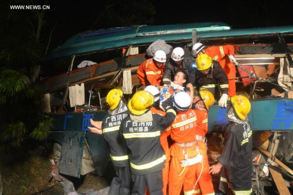 Rescuers transfer an injured woman after a passenger bus collided with a truck in Tengxian county of Wuzhou City, south China's Guangxi Zhuang Autonomous Region, Aug 24, 2014. (Xinhua/Li Yanming)