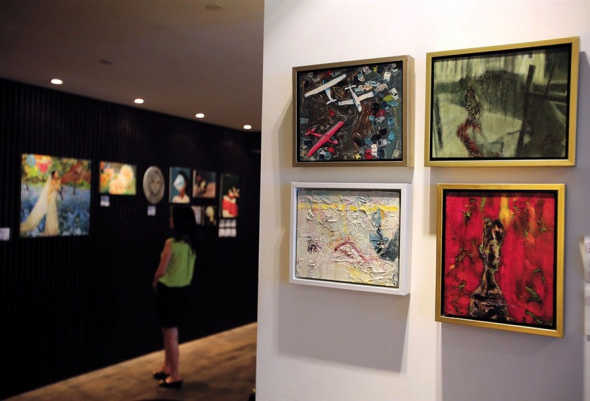 A visitor appreciate paintings by Chinese artists Meng Yangyang and Liu Na.  Wang Rongjiang 