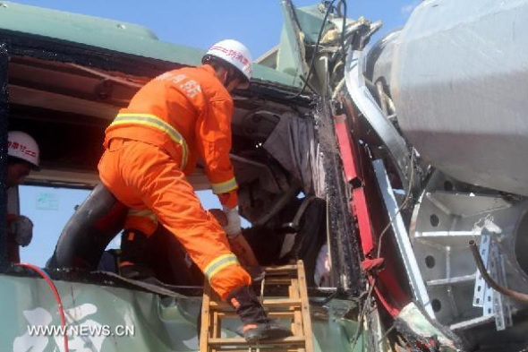 A fire fighter takes part in a rescue operation at the site where a bus collided head-on with a truck on a highway in Guazhou County in the city of Jiuquan, northwest China's Gansu Province, Aug 26, 2014.  (Xinhua/Gao Ming)