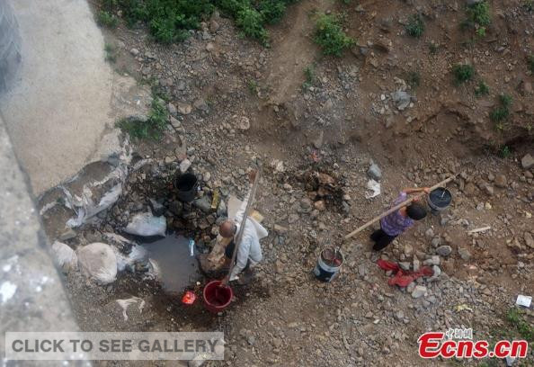 Residents fetch water from a puddle at Longtou village of Zhifang town in Songxian county in Henan province on August 4, 2014. The province is suffering from record draught in 63 years. [Photo: China News Service / Wang Zhongju] 