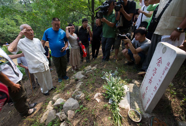 Jia Shanming (left), 97, a veteran soldier who participated in the War of Resistance against Japanese Aggression (1937-45) salutes on Aug 8 at the mausoleum of his battalion commander, Yu Entao, who died during the war. Luo Xiaoguang / Xinhua
