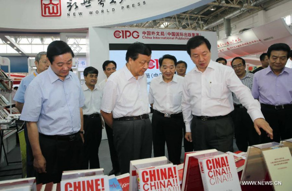 Liu Yunshan (2nd L front), a Standing Committee member of the Communist Party of China Central Committee Political Bureau, learns about the book publishing on introducing China's development with foreign language while visiting the Beijing International Book Fair in Beijing, China, Aug. 31, 2014. (Xinhua/Liu Weibing) 