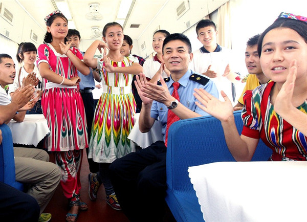 High school students from the Xinjiang Uygur Autonomous Region sing and dance for the train conductor after arriving in Shanghai yesterday. The train brought 1,500 Xinjiang students who will study in Shanghai. — Xinhua 