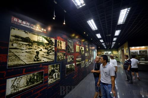 COMMEMORATING THE PAST: Visitors view historic photos from China's War Against Japanese Aggression at a memorial in Zhijiang, Hunan province, a county that witnessed the Japanese army's surrender to China in 1945 (BAI YU)
