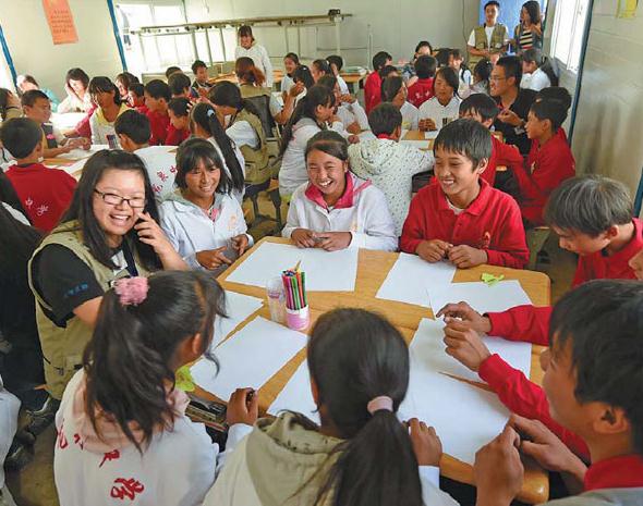 Students at the Longquan Middle School in Ludian county, Yunnan province, which was ravaged by a deadly earthquake last month, participate in a group counseling session as the first class of the new semester on Monday. Lin Yiguang / Xinhua