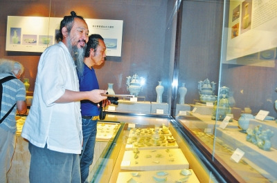 Ceramic artists from around the world admire different stages of work in the Ru Porcelain Museum, in Ruzhou, Henan province, on Aug 26. [Photo by Wang Guofeng/dahe.cn]