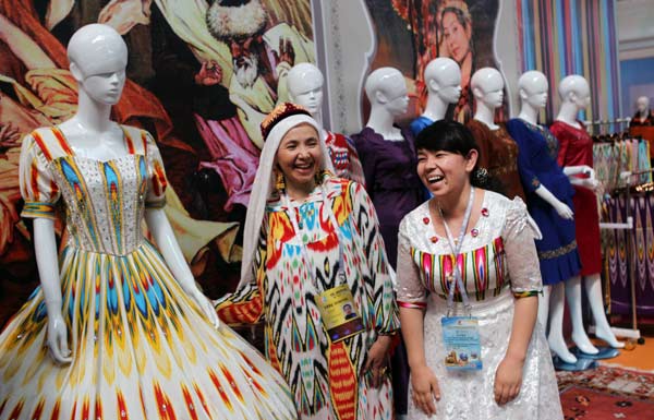 An exhibitor (center) shows textiles in the Xinjiang International Exhibition Center in Urumqi, capital of the Xinjiang Uygur autonomous region, on Tuesday during the China-Eurasia Expo. Most of the textiles on display were made by enterprises in Xinjiang. ZOU HONG / CHINA DAILY  