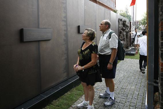 A couple from the United States seek the name of an uncle on a memorial wall on Tuesday in Shanghai. The wall lists 13,732 names of Jewish refugees from Europe who found a haven in Shanghai during World War II. It was an open city that didn't require visas.[Photo/Xinhua]