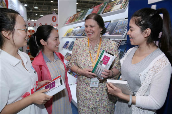 Chinese readers talk with a Russian author at the booth for Russia during the fair. Photo by Chen Xiaogen/China Daily
