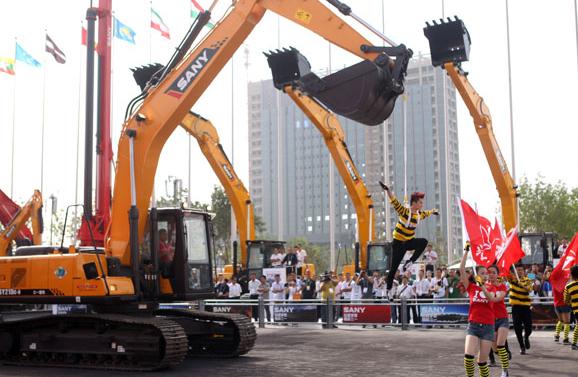 Employees from Sany Heavy Industry, a major engineering machinery manufacturer in China, perform stunts with the company's excavators during the fourth China-Eurasia Expo in Urumqi on Wednesday. Zou Hong / China Daily