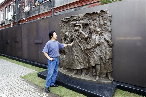 Chinese artist He Ning stands next to the memorial wall at the Shanghai Jewish Refugees Museum.