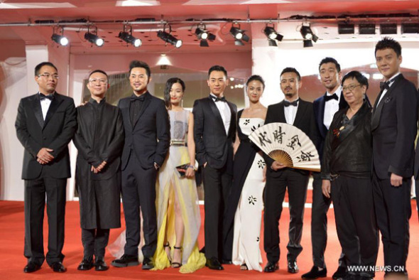 Cast members of the movie The Golden Era pose on the red carpet for the awards ceremony at the 71st Venice Film Festival, in Lido of Venice, Italy on Sept. 6, 2014. The Golden Era directed by Ann Hui was screened as the closing film for the festival. (Xinhua/Liu Lihang)