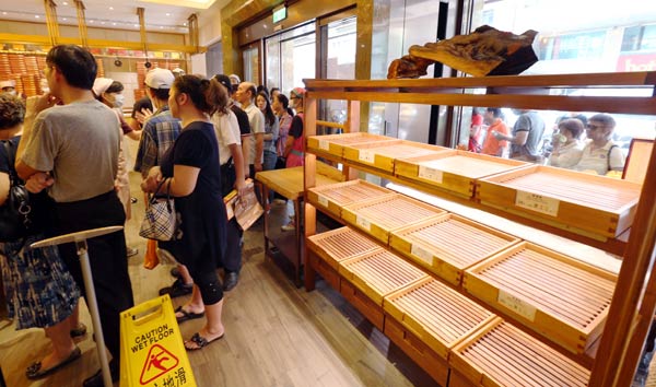 Customers at Taipei Leechi dessert store wait next to emptied shelves to be reimbursed for the cookies they bought in the shop, in Taipei, Taiwan, on Tuesday. The store has used lard oil tainted with recycled waste oil manufactured by Chang Guann Co in the process of baking some cookies. Provided to China Daily