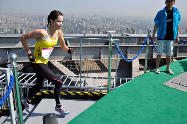 Suzy Walsham wins the title among female professionals during the 2013 China World Summit Wing Vertical Run, taking 11 minutes 56 seconds to climb the 2,041 steps. She defended her title this year on Sunday,Sept 7, 2014. [Photo provided to chinadaily.com.cn]  