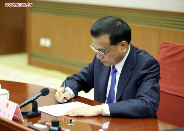 Chinese Premier Li Keqiang signs a decree of the State Council on the appointment of Chui Sai On as the fourth-term chief executive of the Macao Special Administrative Region (SAR) in Beijing, capital of China, Sept 17, 2014. (Xinhua/Ding Lin)