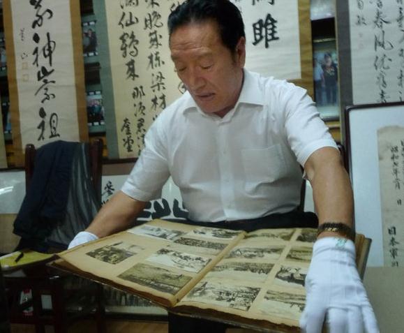 Song Jinhe, a 67-year-old retired cadre in Heilongjiang province, shows documents and photographs he has collected that feature Japan's historical aggression against China. Zhou Huiying / China Daily