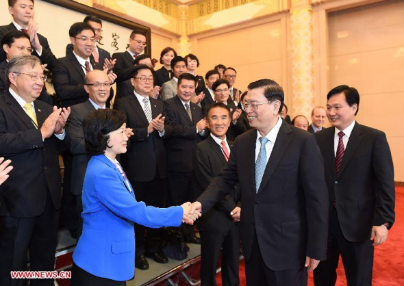 Zhang Dejiang (R, front), chairman of the Standing Committee of China's National People's Congress (NPC), shakes hands with Regina Ip, chair of Hong Kong's New People's Party, in Beijing, capital of China, Sept. 19, 2014. (Xinhua/Liu Jiansheng)