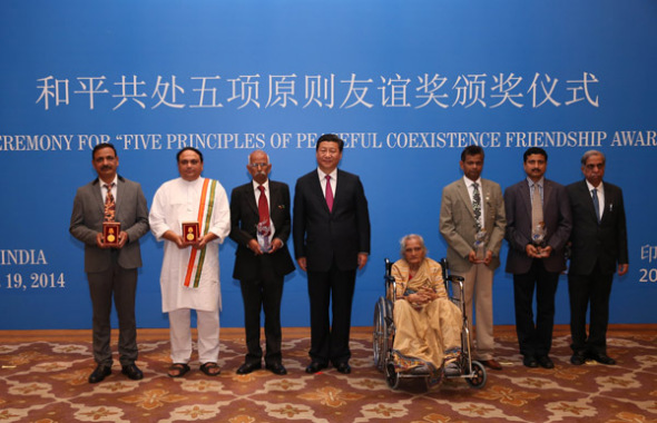 President Xi Jinping has his photo taken with awardees after presenting them with the Friendship Award of Five Principles of Peaceful Coexistence in New Delhi on Friday. Among them is Manorama Kotnis (in wheelchair), the 93-year-old sister of the late Dr Dwarkanath Kotnis, who went to China in 1938 to provide medical assistance during the Japanese invasion. Pang Xinglei / Xinhua