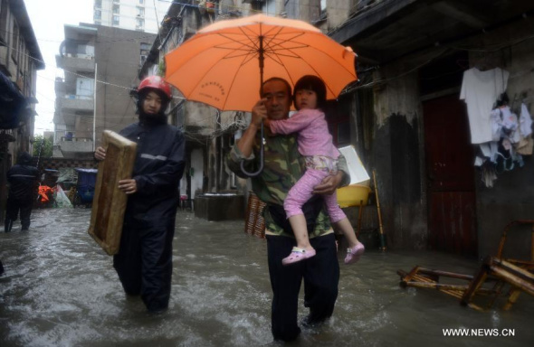 A rescuer help evacuate residents in the Jiaojiang district of Taizhou city, east China's Zhejiang Province, Sept. 22, 2014. According to the National Meteorological Center (NMC), Typhoon Fung-Wong is expected to make a landfall on the coastal areas in Zhejiang province Monday afternoon or at dusk. (Xinhua/Han Chuanhao)