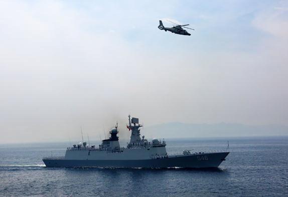 A missile frigate and helicopter join in the maritime memorial ceremony on Aug 27. CHA CHUNMING / XINHUA 