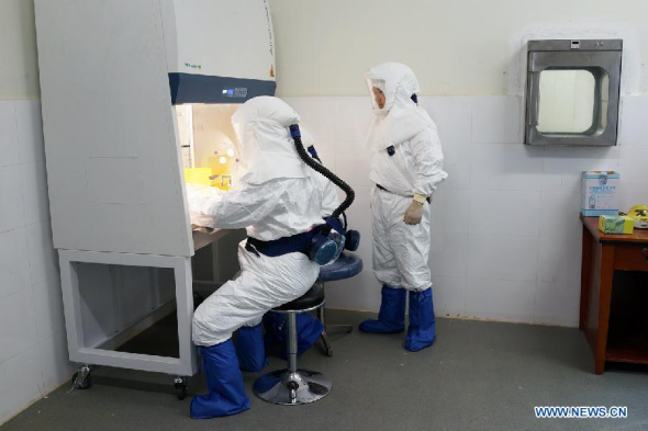 Medical experts of a laboratory team from the Chinese Center for Disease Control and Prevention test samples of Ebola virus at Sierra Leone-China Friendship Hospital in Freetown, capital of Sierra Leone, Sept 25, 2014. (Xinhua)