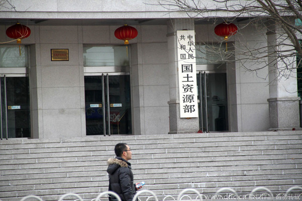 A pedestrian walks past the Ministry of land and Resources in Beijing, China, 10 February 2013. [Photo: dfic.cn]