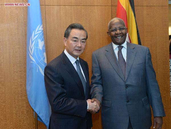 Chinese Foreign Minister Wang Yi (L) meets with Sam Kahamba Kutesa, president of the 69th session of the UN General Assembly, at the UN headquarters in New York, on Sept 25, 2014. [Photo/Xinhua]    