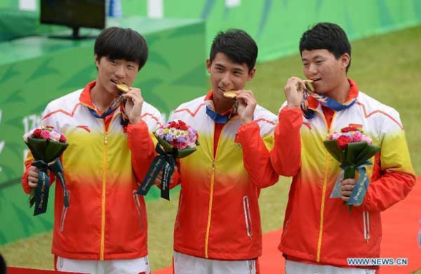 Chinese athletes Yong Zhiwei (L), Qi Kaiyao (C) and Gu Xuesong pose on the podium during the awarding ceremony of the recurve men's team match of archery at the 17th Asian Games in Incheon, South Korea, Sept 28, 2014. (Xinhua/Wang Peng)