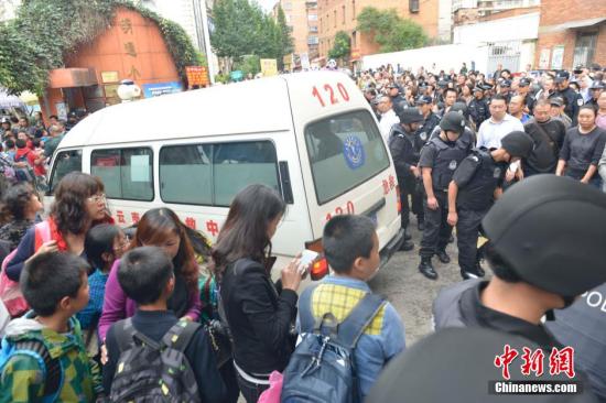 The ambulence is about to leave school and parents wait outside the school gate anxiously on Sept 26, 2014. [Photo: China News service / Zhong Xin]