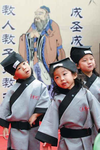 Children recite traditional literary works at a ceremony to commemorate the 2,565th birthday of Confucius at the QYD International Kindergarten in Beijing on Sunday.  Wang Jing / China Daily