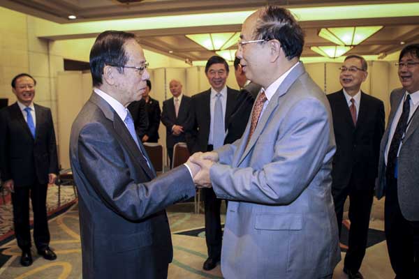 Zhao Qizheng (right), former minister of the State Council Information Office, meets Yasuo Fukuda, former Japanese prime minister, during the 10th Beijing-Tokyo Forum in Tokyo on Sunday. Zhao has taken part in all 10 forums. Zou Hong / China Daily  