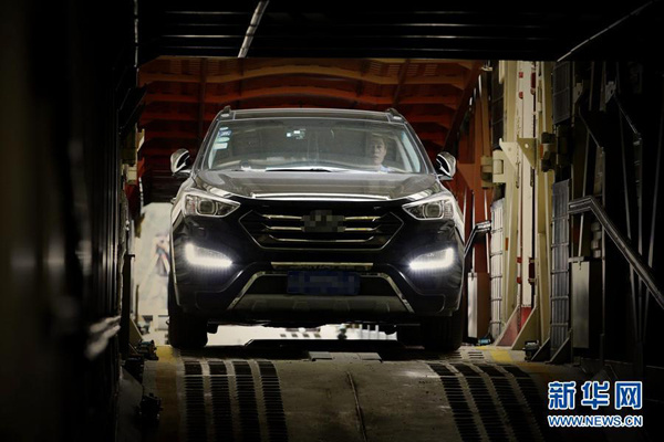 Workers load a car onto a Beijing-Hangzhou freight train on Sunday, September 28, 2014. The train is specially arranged by the Beijing Railway Administration for those who want to have a self-drive National Day holiday. With the service, passengers on rail lines linking Beijing and Hangzhou can reach destinations simultaneously with their cars transported by the specific freight train. Over 50 cars will be transported during the upcoming golden week holiday under the service, said the Beijing Railway Administration. [Photo/Xinhua]