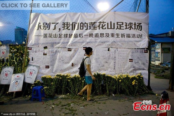 Yellow chrysanthemums and banners are hung on the fence of a football field at Futian district in Shenzhen city of south China's Guangdong province on Aug. 31, 2014. [Photo/CFP] 