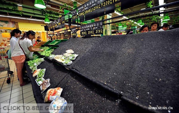 The shelf for vegetable is almost empty in a supermarket in Haikou, capital of south China's island of Hainan Province, Sept. 15, 2014. The Hainan government issued the highest Grade I alert at 10 a.m. Monday against typhoon Kalmaegi, which was spotted on the sea 645 km southeast of Leizhou City, Guangdong Province at 4 p.m. Monday. People in Hainan flocked into supermarkets to store up food and water. (Xinhua/Guo Cheng)