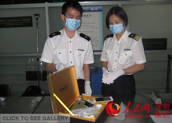 Three iPhone 6 hidden in a tea box are displayed by Shenzhen customs on Sept 22, 2014. More than 600 iPhone 6 have been confiscated in only three days since they hit shelves in Hong Kong last Friday. Some smugglers admitted to attempting to smuggle the new smartphone onto the mainland, where they are still not legally available. [Photo: Shenzhen customs]