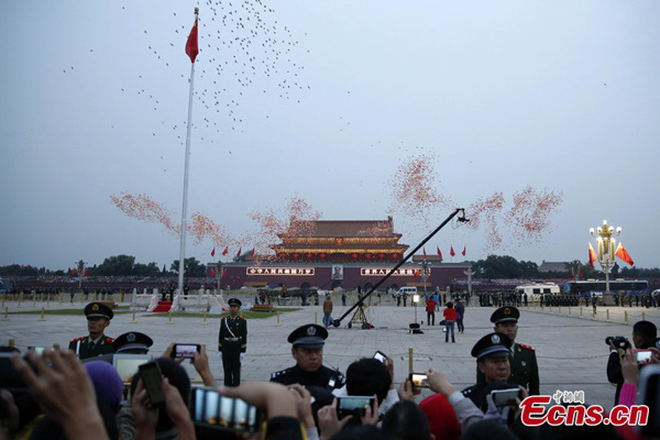 People watch the national flag raising ceremony at the Tian'anmen Square in Beijing, capital of China, October 1, 2014. Tens of thousands of people gathered at the Tian'anmen Square to watch the national flag raising ceremony at dawn on Wednesday, in celebration of the 65th anniversary of the founding of the People's Republic of China. (Photo: China News Service/Han Haidan)
