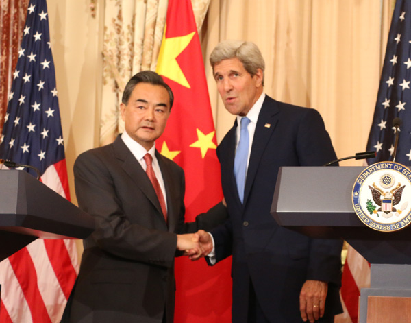 Chinese Foreign Minister Wang Yi (left) shakes hands with US Secretary of State John Kerry on Wednesday after they addressed the press in the Ben Franklin Room of the State Department in Washington, ahead a bilateral meeting on a wide range of issues. [Photo by Chen Weihua/China Daily]