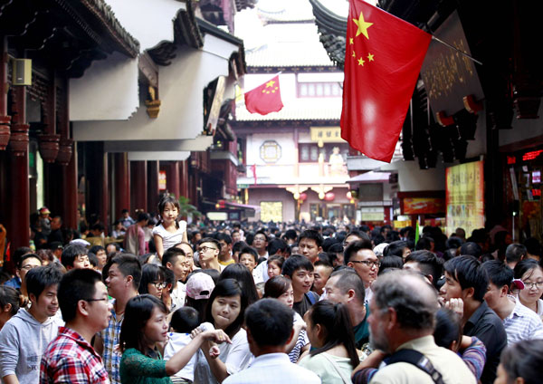 Tourists crowd into a commercial street in Yuyuan Garden in Shanghai on Wednesday, the start of the National Day golden week holiday. [Photo by Ding Ting / China Daily]