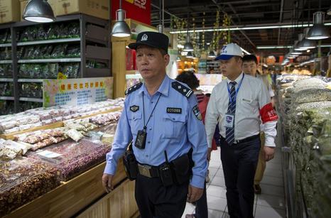 A police officer and a security guard patrol a supermarket at Cloud Nine yesterday.  Yang Bo