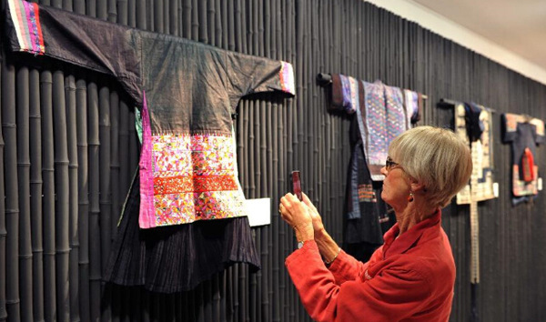 A visitor looks at an embroidery work during the 2014 China Miao Embroidery Exhibition for Public Benefit at Xinhua Photo Gallery in downtown Paris on Sept 30, 2014. [Photo/Xinhua]  