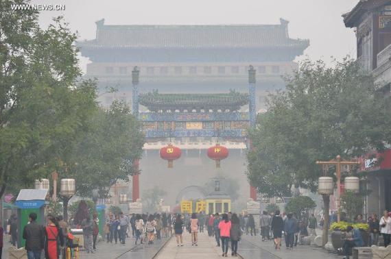 Tourists visit the Qianmen Street in smog-shrouded Beijing, capital of China, Oct. 9, 2014. [Photo: Xinhua/Li Xin] 