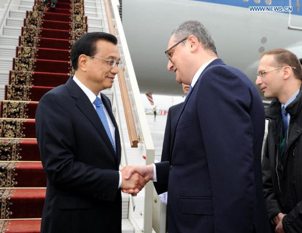 Chinese Premier Li Keqiang (L) is welcomed by a Russian senior official upon his arrival at an airport in Moscow, Russia, Oct. 12, 2014. Li arrived here Sunday afternoon for an official visit to Russia and he will attend the 19th China-Russia Prime Ministers' Regular Meeting. (Xinhua/Rao Aimin)