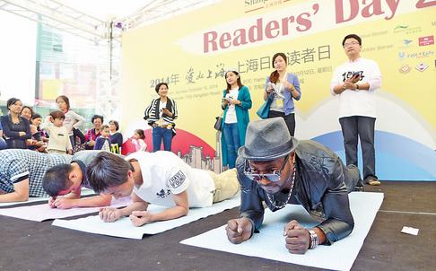 Visitors to Shanghai Daily Readers Day take part in a plank competition yesterday at the Kerry Parkside in Pudong New Area.  Wang Rongjiang