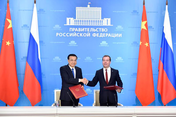 Premier Li Keqiang (L) shakes hands with Russian Prime Minister Dmitry Medvedev after they sign a joint statement following the 19th China-Russia Prime Ministers Regular Meeting in Moscow on Oct 13, 2014. [Photo/Xinhua]
