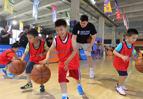 Former NBA allstar center Yao Ming instructs a group of youngsters at the NBA Yao School on June 21. To help develop young Chinese players, the NBA has brought in topnotch coaches and trainers, and has also established a joint coaching program with the Chinese Basketball Association. WANG YING / XINHUA 