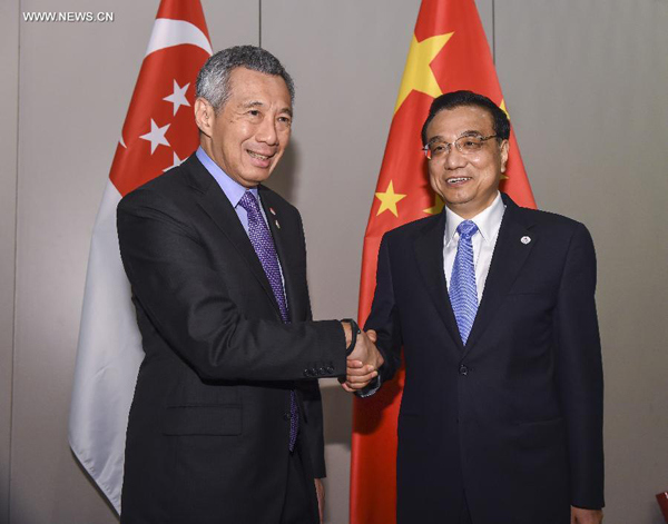 Chinese Premier Li Keqiang (R) meets with Singapore's Prime Minister Lee Hsien Loong, in Milan, Italy, Oct. 17, 2014. (Xinhua/Li Xueren)