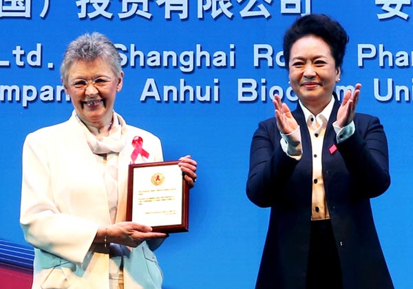 First lady Peng Liyuan applauds after presenting an award to Francoise Barre-Sinoussi from the Institute Pasteur in France at the 2014 National Conference on HIV/AIDS in Beijing. Barre-Sinoussi won a Nobel Prize for identifying the virus. YAO DAWEI / XINHUA