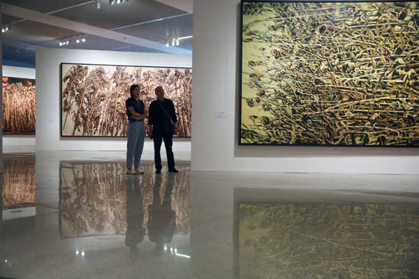 Artist Xu Jiang's new exhibition at the National Museum of China features sunflowers that are distorted, dark, withered and growing densely. [Photo by Jiang Dong/China Daily]
